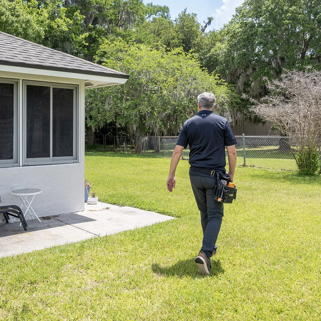Kit Brucker walking across a lawn toward the house